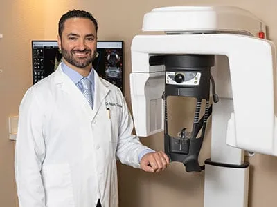Dr. Ovadia Standing in front of the Cone Beam 3D CT scanner.