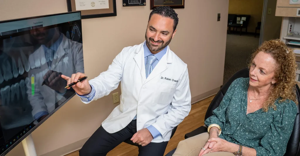 Image of Dr. Ovadia showing a patient dental implants in Dallas.