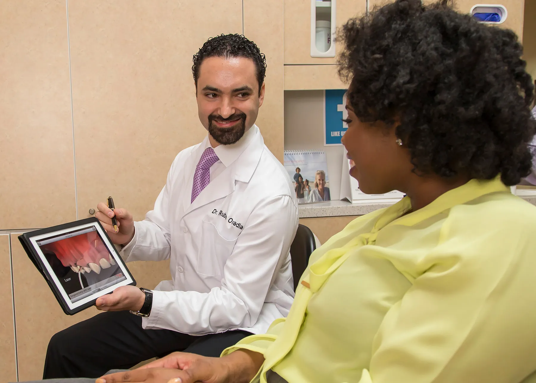 Dr. Ovadia showing his patient a dental treatment on his tablet