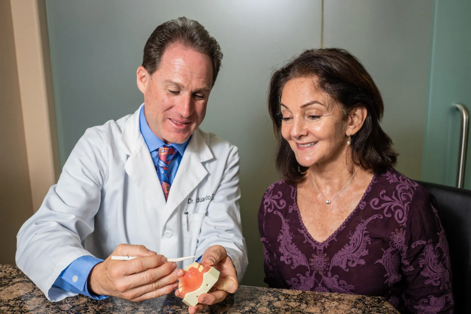Dr. Tanur showing a patient a teeth model