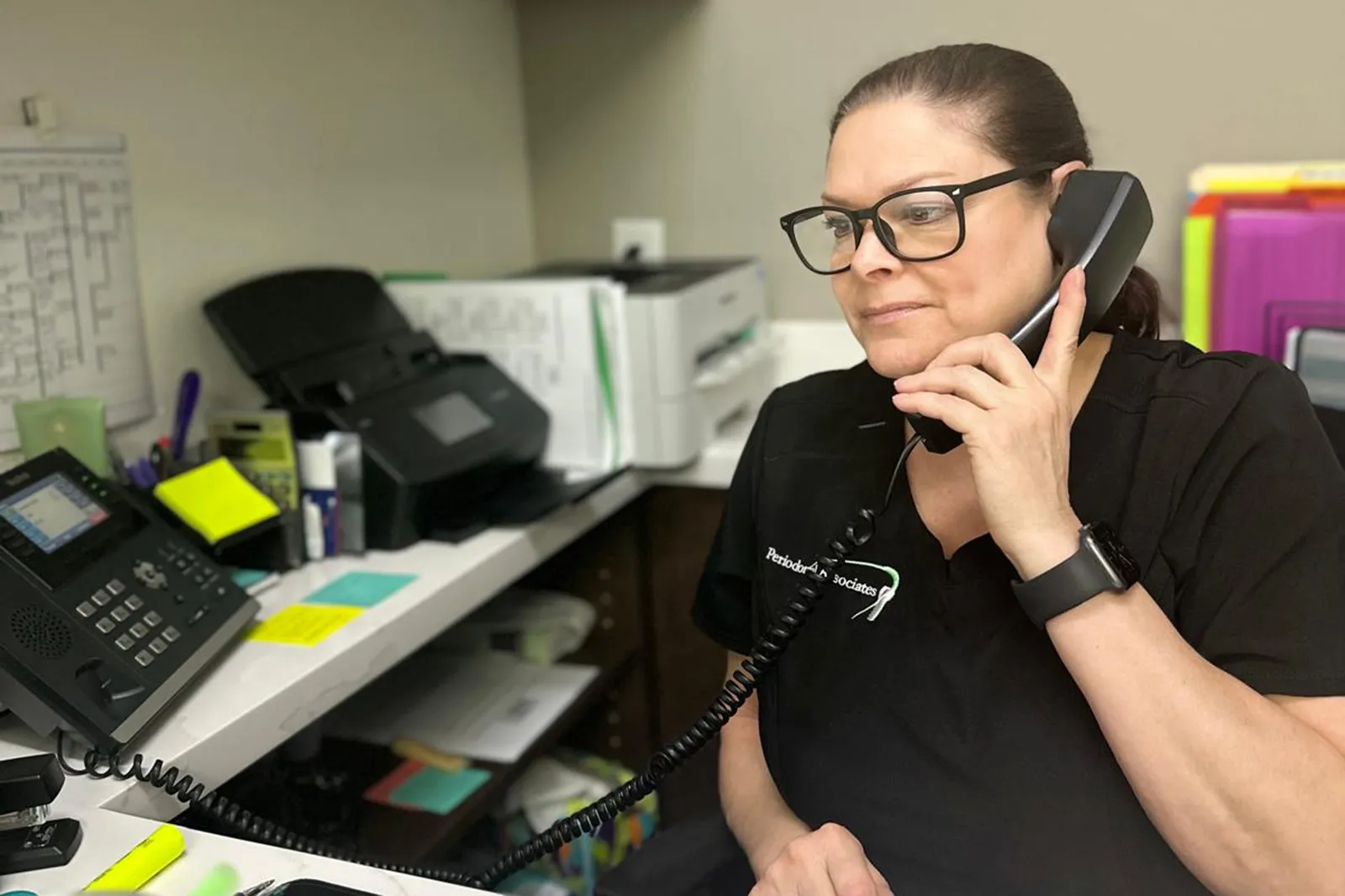 A dental assistant answering the phone
